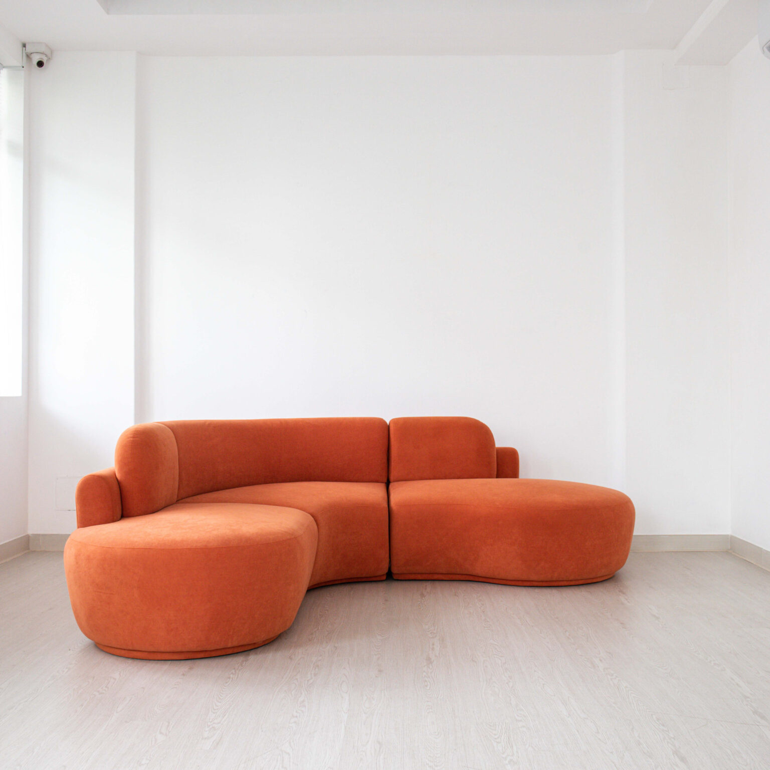 Sofa màu cam dáng cong trên nền sáng